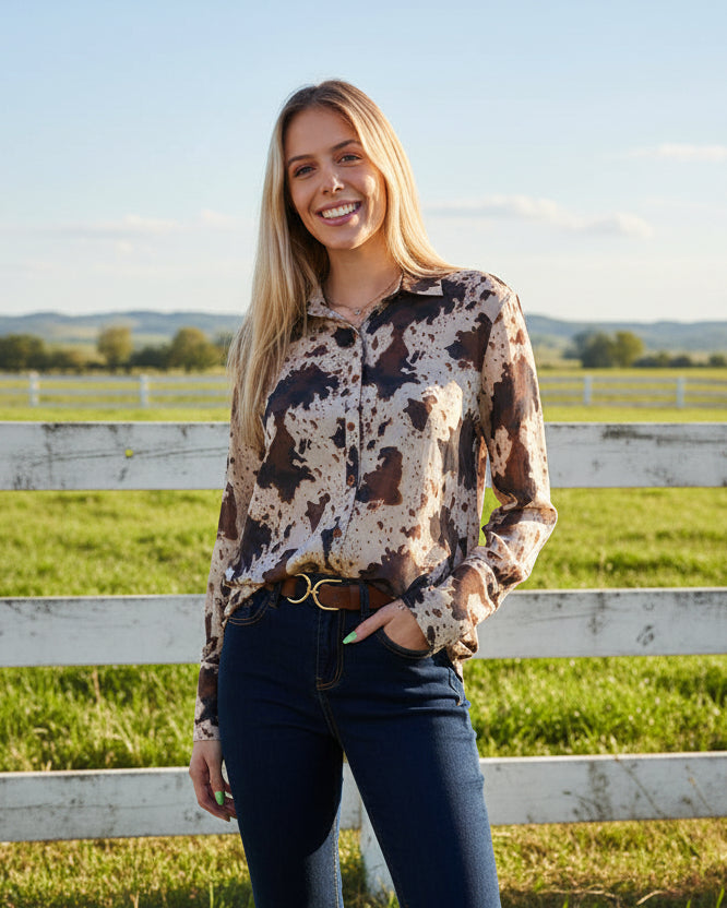 Woman wearing a patterned blouse and jeans on a white background