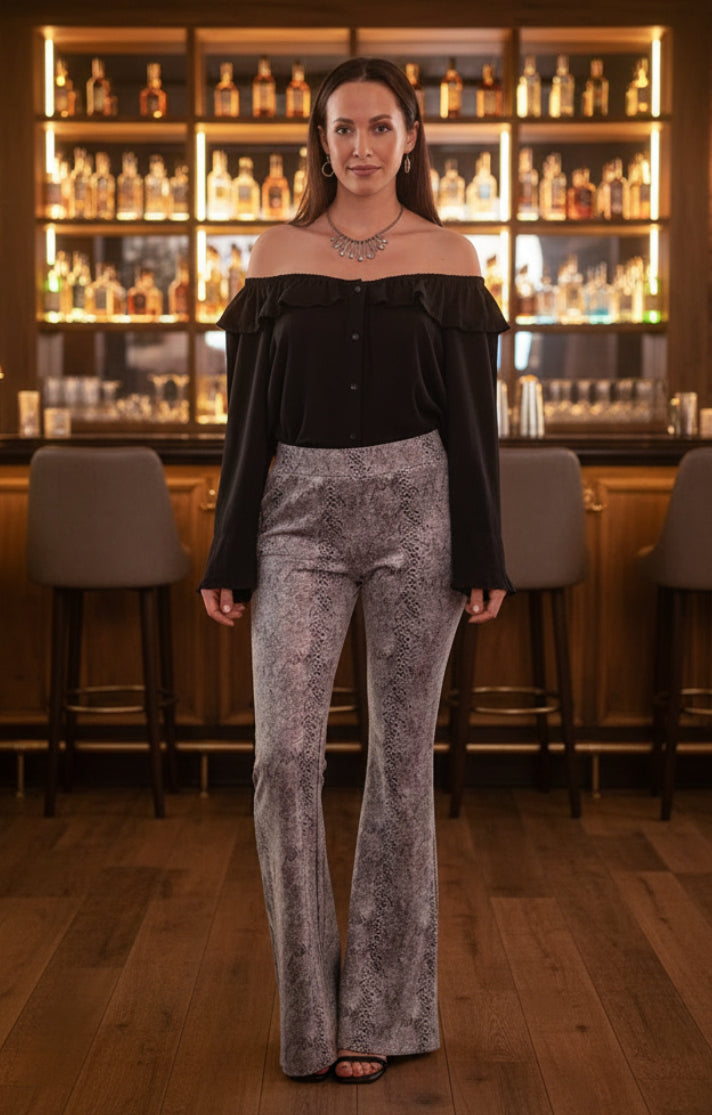 Woman wearing a black off-shoulder top and snake print pants