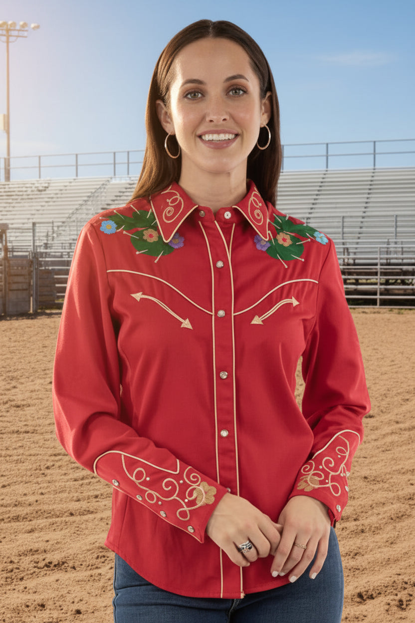 Woman wearing a red embroidered pearl snap shirt in an outdoor setting