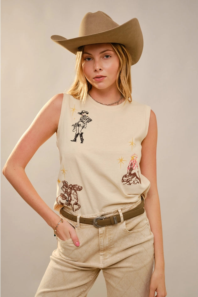 Woman wearing a sleeveless beige top with cowboy graphics and a cowboy hat on a plain background